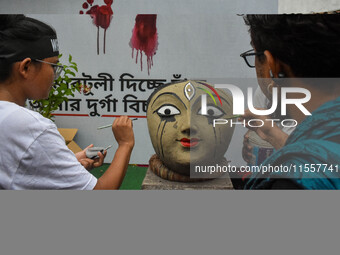 Renowned artist Sanatan Dinda paints the head of a Durga idol with his own artistic expression towards the protest against the rape and murd...