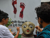 Renowned artist Sanatan Dinda paints the head of a Durga idol with his own artistic expression towards the protest against the rape and murd...