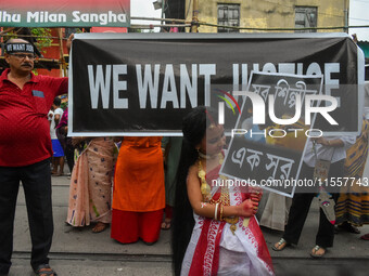 A little girl dressed as Devi Durga poses for the camera in front of a banner demanding ''We Want Justice'' during a protest rally in Kolkat...