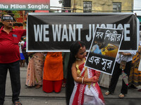 A little girl dressed as Devi Durga poses for the camera in front of a banner demanding ''We Want Justice'' during a protest rally in Kolkat...