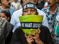 A girl carries the head of a Durga idol with a protest bandana wrapped around the eye during a protest rally in Kolkata, India, on September...