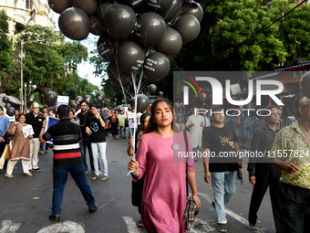 People march along a street during a protest condemning the rape and murder of a trainee medic at a government-run hospital in Kolkata, Indi...