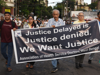 Members of the West Bengal Junior and Senior Doctors' Front march along a street during a protest condemning the rape and murder of a traine...