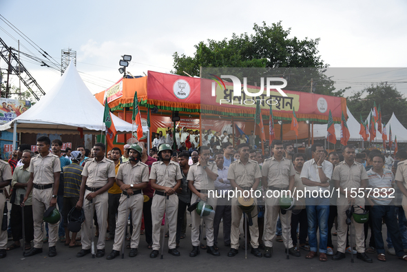 Police stand in front of the BJP agitation stage during a protest condemning the rape and murder of a trainee medic at a government-run hosp...