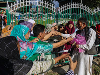 A Kashmiri Muslim devotee distributes sweets as offerings during annual congregational prayers called ''Khoja Digar'' on the 3rd of Rabi-ul-...