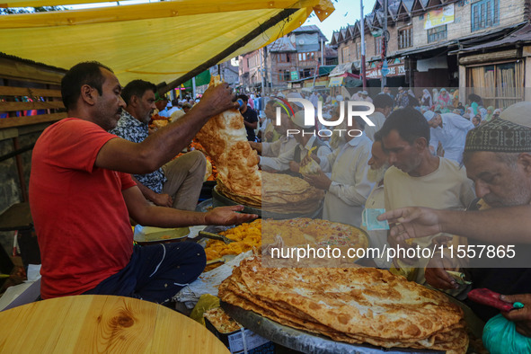 Kashmiri Muslim devotees buy local snacks from a vendor outside the shrine of Sufi Saint Khawaja Naqashband Sahib in Srinagar, Jammu and Kas...