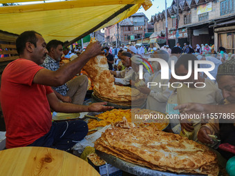 Kashmiri Muslim devotees buy local snacks from a vendor outside the shrine of Sufi Saint Khawaja Naqashband Sahib in Srinagar, Jammu and Kas...