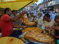 Kashmiri Muslim devotees buy local snacks from a vendor outside the shrine of Sufi Saint Khawaja Naqashband Sahib in Srinagar, Jammu and Kas...