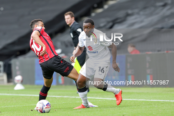 Milton Keynes Dons' Aaron Nemane skips past Walsall's George Hall during the first half of the Sky Bet League 2 match between MK Dons and Wa...