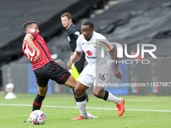 Milton Keynes Dons' Aaron Nemane skips past Walsall's George Hall during the first half of the Sky Bet League 2 match between MK Dons and Wa...