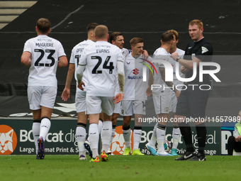 Callum Hendry celebrates with teammates after scoring for Milton Keynes Dons to take the lead, making it 1-0 against Walsall, during the fir...