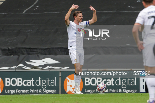 Alex Gilbey calls over players to celebrate Callum Hendry's goal for Milton Keynes Dons, taking the lead 1-0 against Walsall, during the fir...