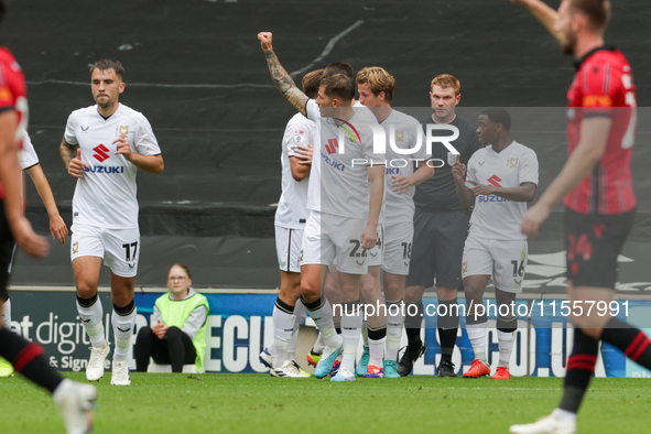 Callum Hendry celebrates with teammates after scoring for Milton Keynes Dons to take the lead, making it 1-0 against Walsall, during the fir...