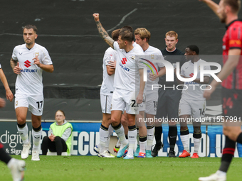 Callum Hendry celebrates with teammates after scoring for Milton Keynes Dons to take the lead, making it 1-0 against Walsall, during the fir...