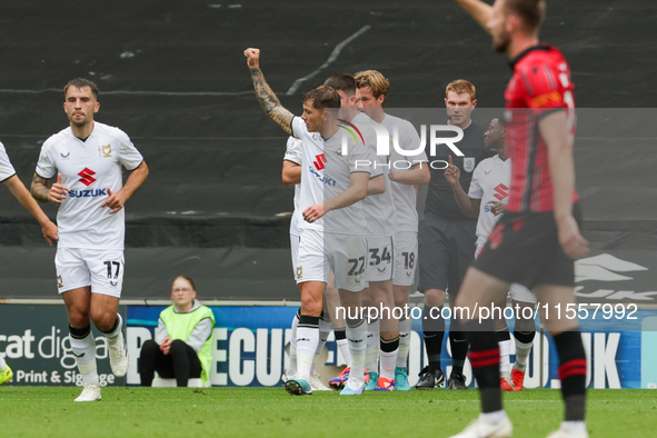 Callum Hendry celebrates with teammates after scoring for Milton Keynes Dons to take the lead, making it 1-0 against Walsall, during the fir...