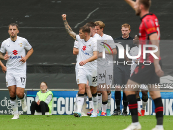 Callum Hendry celebrates with teammates after scoring for Milton Keynes Dons to take the lead, making it 1-0 against Walsall, during the fir...