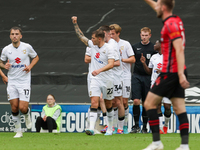 Callum Hendry celebrates with teammates after scoring for Milton Keynes Dons to take the lead, making it 1-0 against Walsall, during the fir...