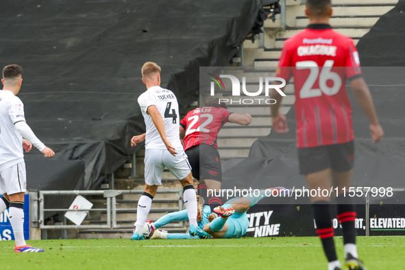 Milton Keynes Dons keeper Tom McGill makes a fingertip save to deny Walsall's Jamie Jellis' effort towards goal during the second half of th...