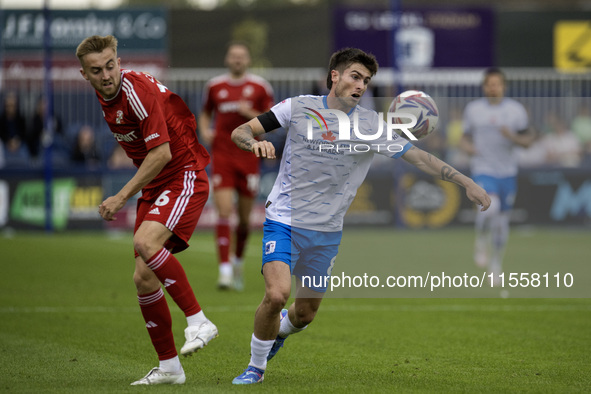 Barrow's Kian Spence competes with Swindon Town's Jack Cain during the Sky Bet League 2 match between Barrow and Swindon Town at Holker Stre...