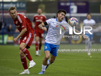 Barrow's Kian Spence competes with Swindon Town's Jack Cain during the Sky Bet League 2 match between Barrow and Swindon Town at Holker Stre...