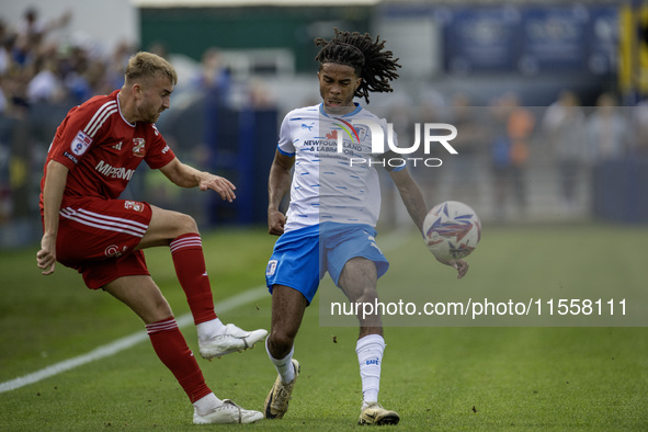 Swindon Town's Jack Cain clears from Barrow's Neo Eccleston during the Sky Bet League 2 match between Barrow and Swindon Town at Holker Stre...