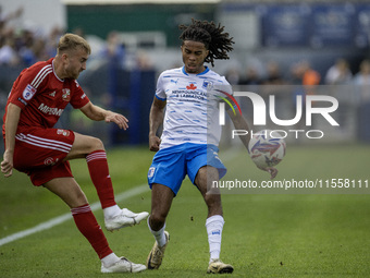 Swindon Town's Jack Cain clears from Barrow's Neo Eccleston during the Sky Bet League 2 match between Barrow and Swindon Town at Holker Stre...