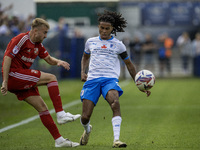 Swindon Town's Jack Cain clears from Barrow's Neo Eccleston during the Sky Bet League 2 match between Barrow and Swindon Town at Holker Stre...