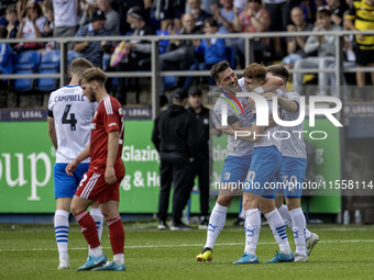 Barrow's Ged Garner celebrates with Dean Campbell and Ben Jackson after scoring their first goal during the Sky Bet League 2 match between B...