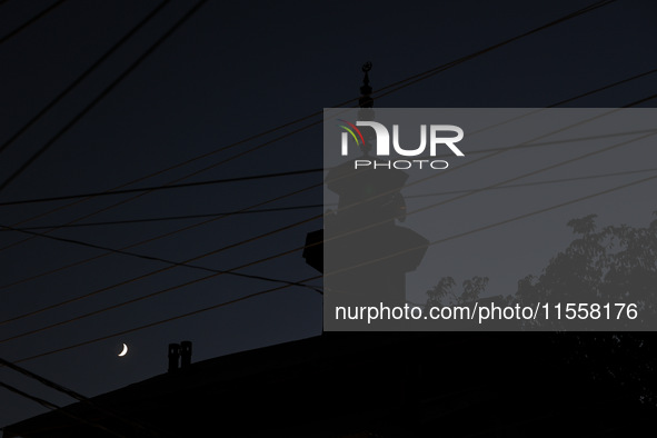 The crescent moon shines behind a mosque in Bandipora, Jammu and Kashmir, India, on September 8, 2024. 