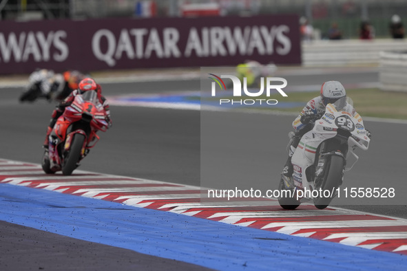 Marc Marquez rides on track in front of Francesco Bagnaia of Italy and the Ducati Lenovo Team during the Race of MotoGP of San Marino at Mis...