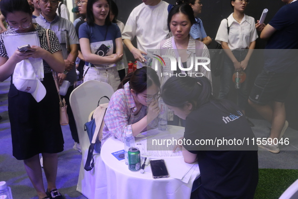 Job seekers learn about the demand for artificial intelligence digital technology positions at a job fair for science and technology talents...