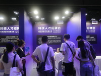 Job seekers learn about the demand for artificial intelligence digital technology positions at a job fair for science and technology talents...