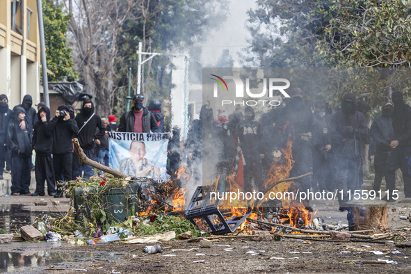 Protesters light barricades at the General Cemetery in Chile on September 8, 2024, where the traditional pilgrimage commemorating the coup d...