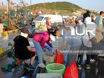 People buy seafood caught at Jimiya fishing port in Qingdao, Shandong province, China, on September 9, 2024. (