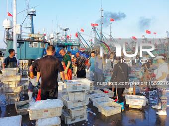 People buy seafood caught at Jimiya fishing port in Qingdao, Shandong province, China, on September 9, 2024. (