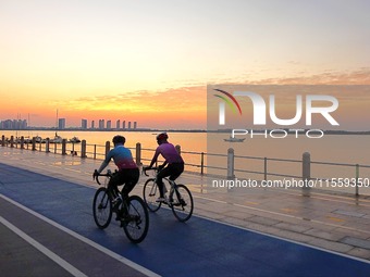 Cyclists ride on Tangdao Bay under the sunrise in Qingdao, China, on September 9, 2024. (