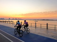 Cyclists ride on Tangdao Bay under the sunrise in Qingdao, China, on September 9, 2024. (