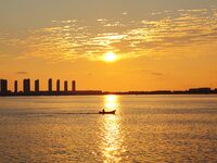 A fishing boat rides in Tangdao Bay illuminated by the rising sun in Qingdao, China, on September 9, 2024. (