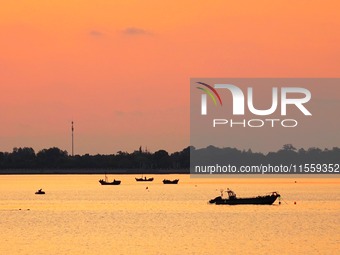 A fishing boat rides in Tangdao Bay illuminated by the rising sun in Qingdao, China, on September 9, 2024. (