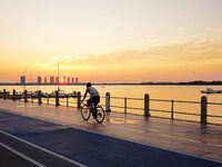 Cyclists ride on Tangdao Bay under the sunrise in Qingdao, China, on September 9, 2024. (