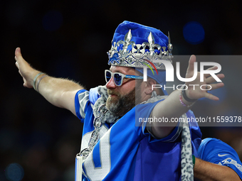 DETROIT,MICHIGAN-SEPTEMBER 9:  A fan in Detroit Lions gear including a crown holds out his arms during a game between the Detroit Lions and...