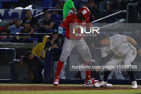 Jose Pirela #67 of Diablos Rojos is at the plate against first baseman Christian Villanueva #14 of Sultanes de Monterrey during the 2024 Kin...