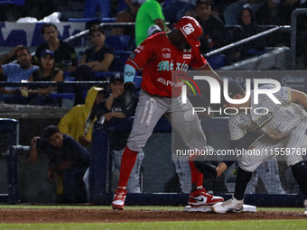 Jose Pirela #67 of Diablos Rojos is at the plate against first baseman Christian Villanueva #14 of Sultanes de Monterrey during the 2024 Kin...