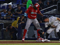 Jose Pirela #67 of Diablos Rojos is at the plate against first baseman Christian Villanueva #14 of Sultanes de Monterrey during the 2024 Kin...