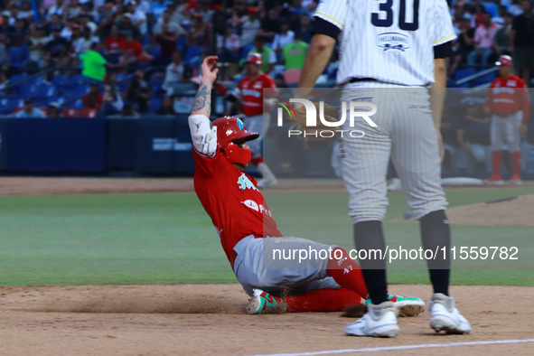 Juan Carlos Gamboa #47 of Diablos Rojos slides to the third base plate during the 2024 King Series match 3 against Sultanes de Monterrey of...