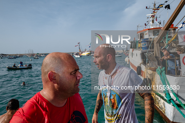 Sailors dive into the sea to greet the statue of Our Lady of Martyrs on the occasion of the patronal feast day in Molfetta, Italy, on Septem...