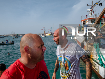 Sailors dive into the sea to greet the statue of Our Lady of Martyrs on the occasion of the patronal feast day in Molfetta, Italy, on Septem...