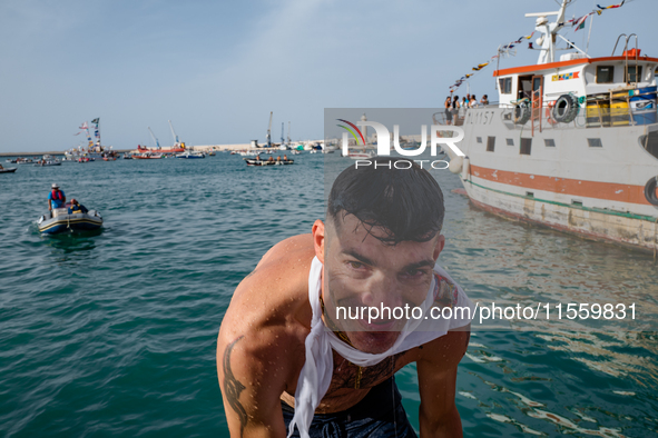 A sailor dives into the sea to greet the statue of Our Lady of Martyrs on the occasion of the patronal feast day in Molfetta, Italy, on Sept...