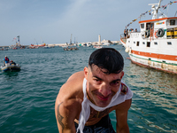 A sailor dives into the sea to greet the statue of Our Lady of Martyrs on the occasion of the patronal feast day in Molfetta, Italy, on Sept...