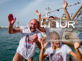 Sailors celebrate and dive into the sea to greet the statue of Our Lady of Martyrs on the occasion of the patronal feast day in Molfetta, It...